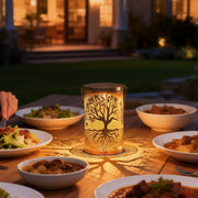 Tree of life lantern illuminating an outdoor dining table with warm, ambient glow.