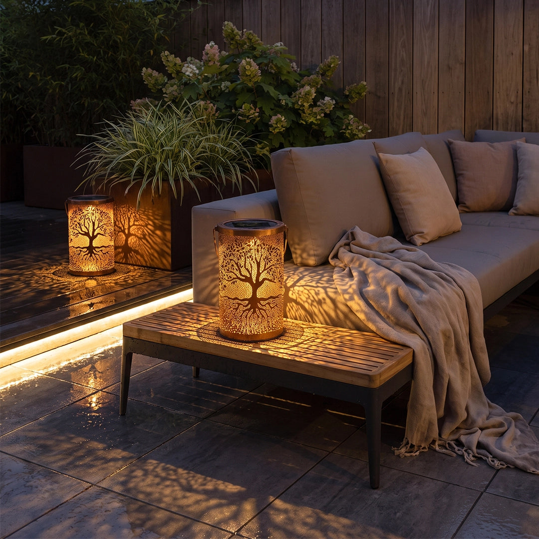 Tree of life lanterns glowing beside an outdoor sofa and casting patterned light across the patio.