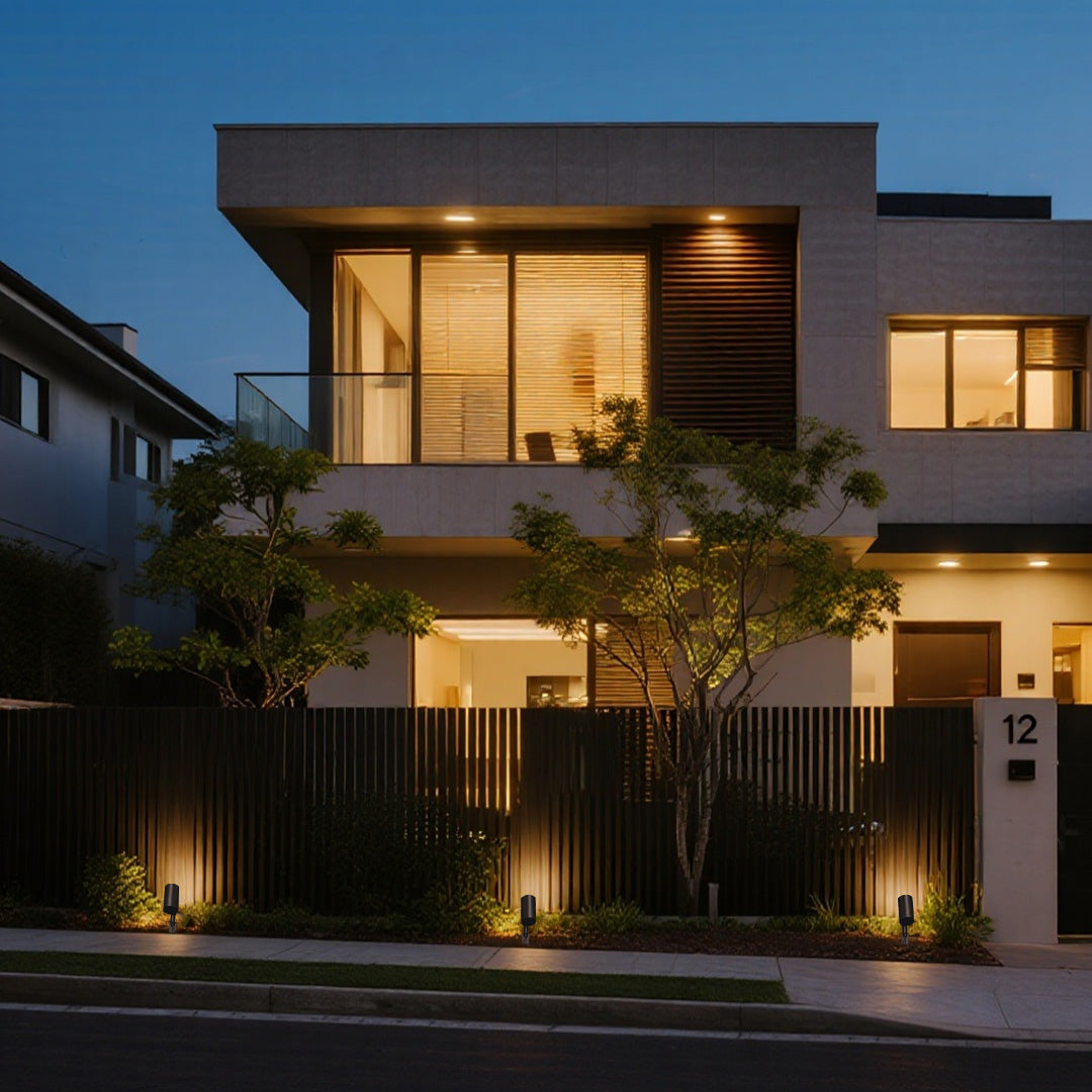 Contemporary home exterior featuring tree spotlights creating ambient landscape illumination at twilight