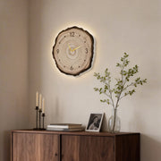 Tree stump wall clock with natural wood finish and a minimalist design, featuring soft LED backlighting for a warm ambiance.