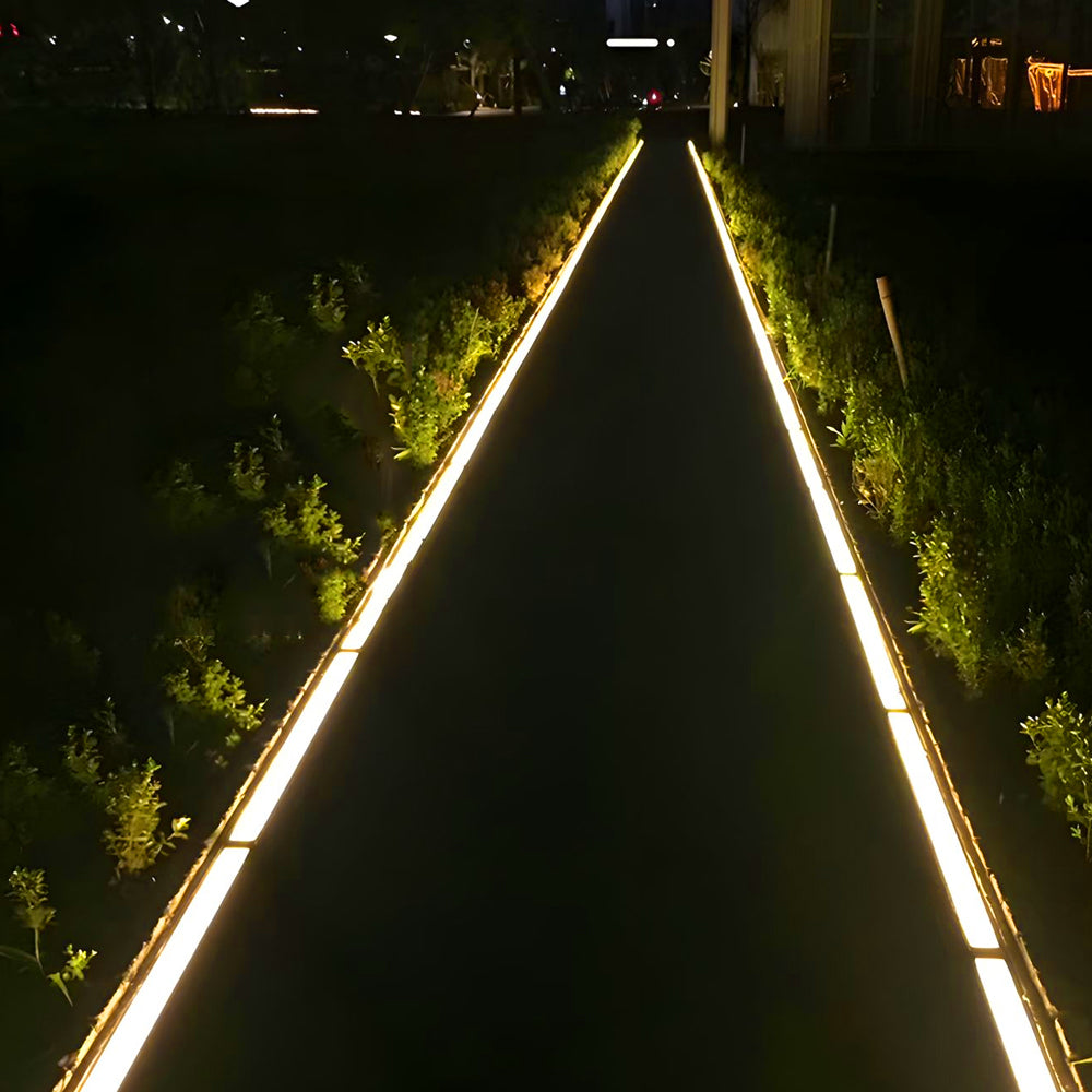 Triangular wooden pathway with embedded LED strip lighting creating geometric illumination pattern in landscaped garden setting