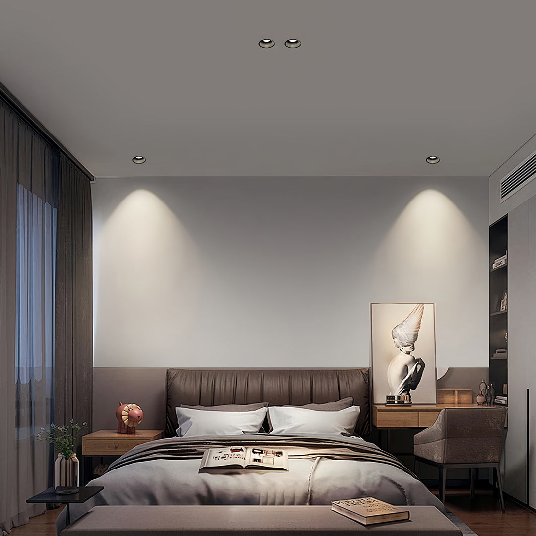 Trimless recessed downlights creating focused lighting in grey contemporary bedroom with platform bed