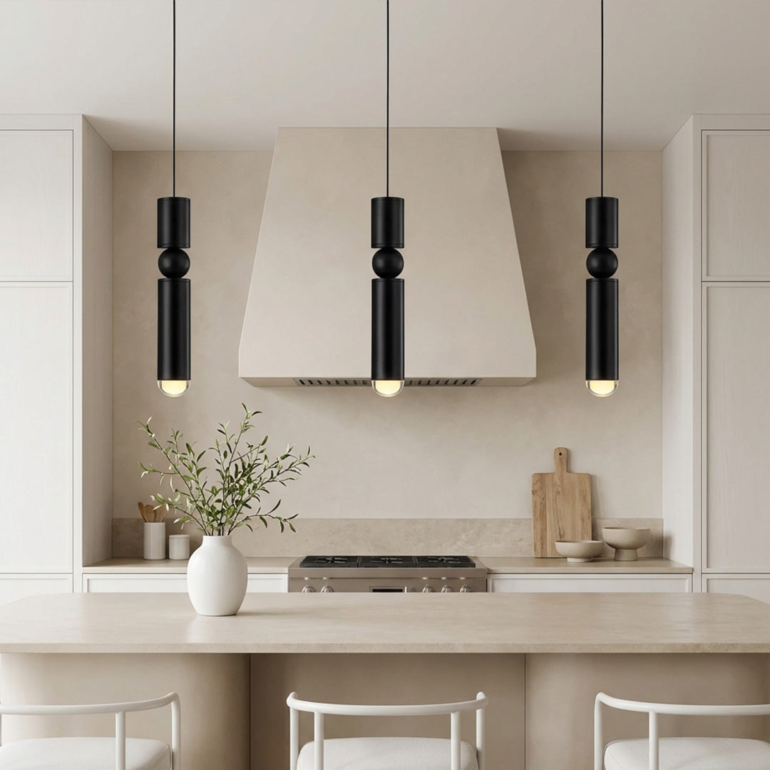 Trio of black cylinder pendant lights featuring a sphere over a luxury marble kitchen island.