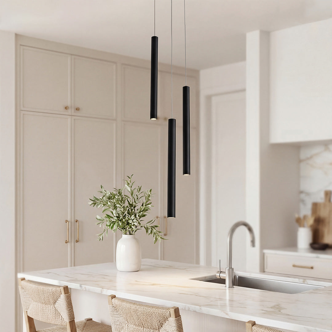Trio of sleek black linear cluster pendant light fixtures over a luxury marble kitchen island.