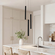 Trio of sleek black linear cluster pendant light fixtures over a luxury marble kitchen island.
