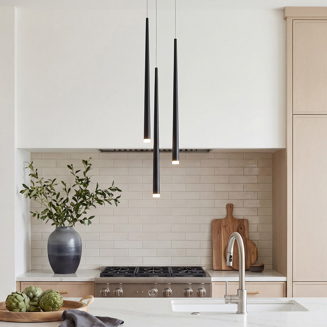 three slim black pendant tubes above a modern kitchen with warm wood details