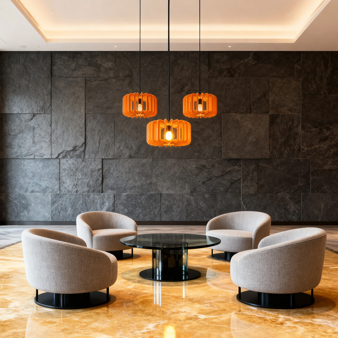 Trio of orange Nordic pendant lights illuminating a modern corporate lobby seating area 