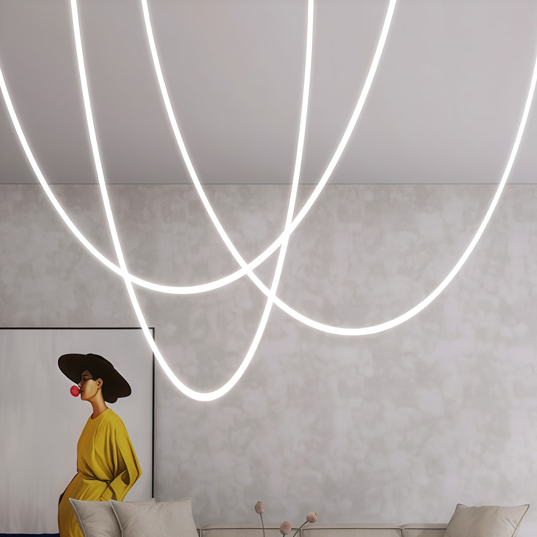 Triple neon pendant lights with cascading design illuminating modern living space with neutral decor.