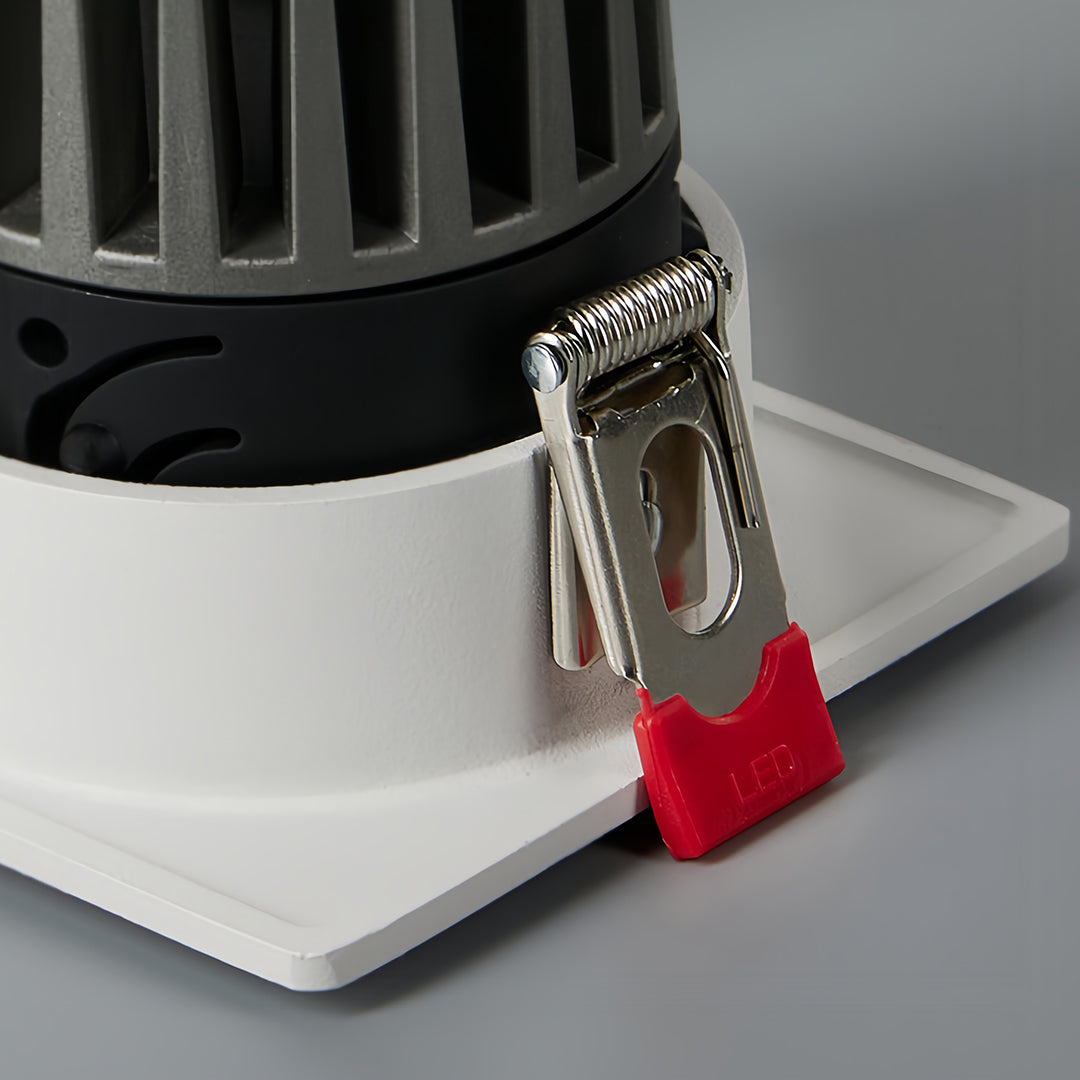 Triple square recessed downlight with black interior and white trim in a contemporary hallway