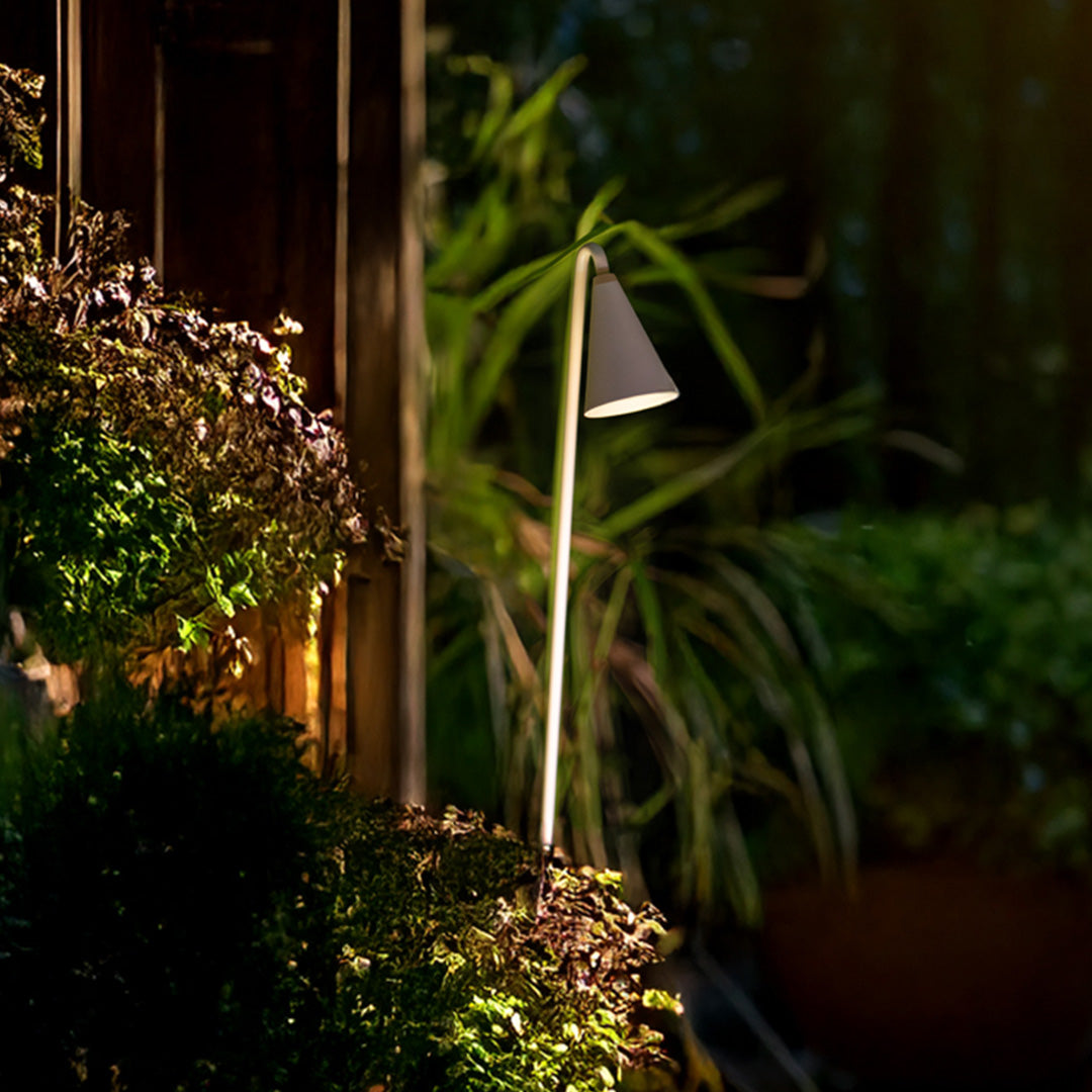 Tropical setting metal landscape lights with dark finish creating atmospheric uplighting among lush green vegetation