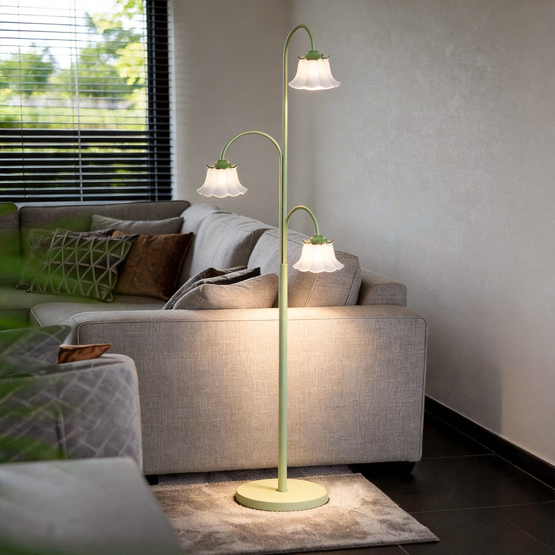 Tulip floor light illuminating a modern living room with a gray sofa and wooden coffee table.