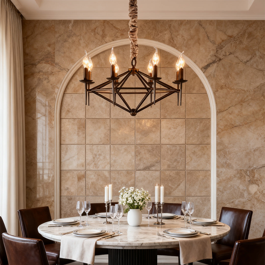 Tuscan style brown chandelier with an exposed candle rack, illuminating a round marble dining table set against a tiled arch wall.