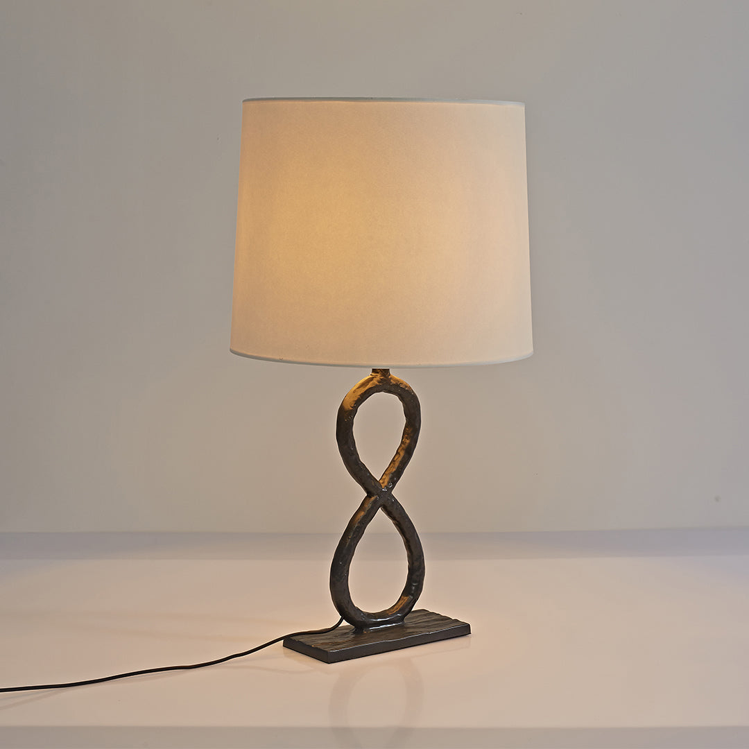 Twisted bronze metal table lamp with drum shade, simple and elegant home decor lighting.