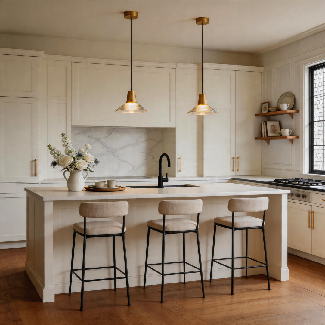 Two glass cone pendant light fixtures hanging in a modern white kitchen over an island counter.