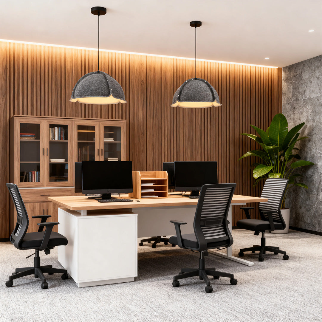 Two large, gray colored pendant light fixtures providing task lighting over wooden desks in a stylish, wood-paneled office.