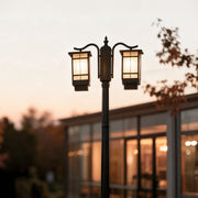 2 head outdoor post light illuminating garden pathway with warm glow at dusk.