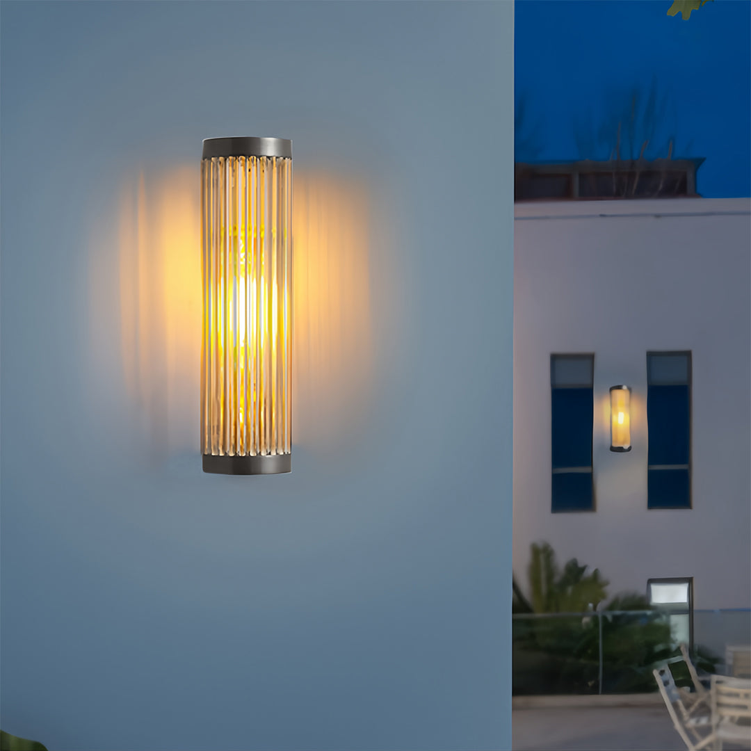 Two narrow outdoor wall LED light fixtures mounted vertically on a smooth white exterior, providing a warm, upward glow at night.