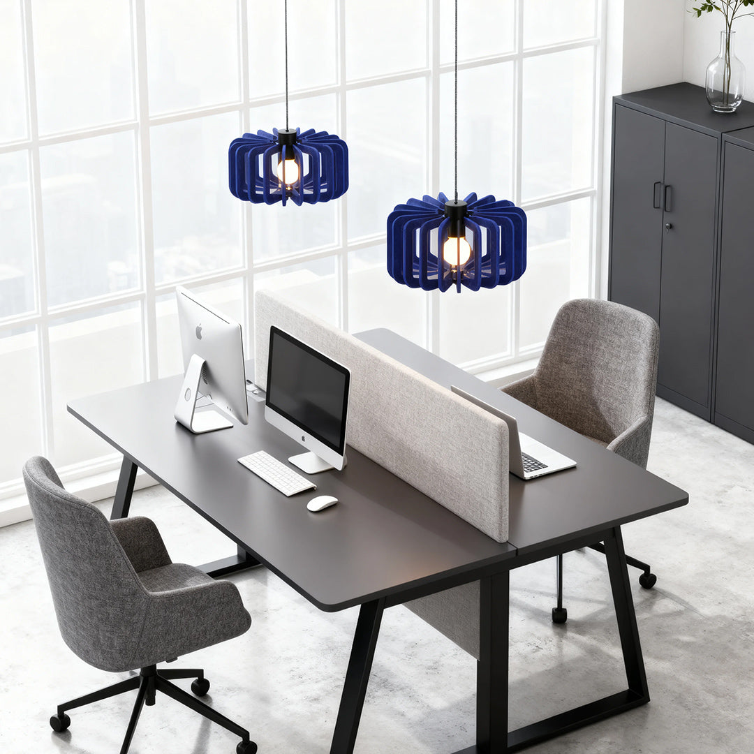 Two navy blue wooden Nordic pendant lights hanging above a contemporary open-plan office desk 