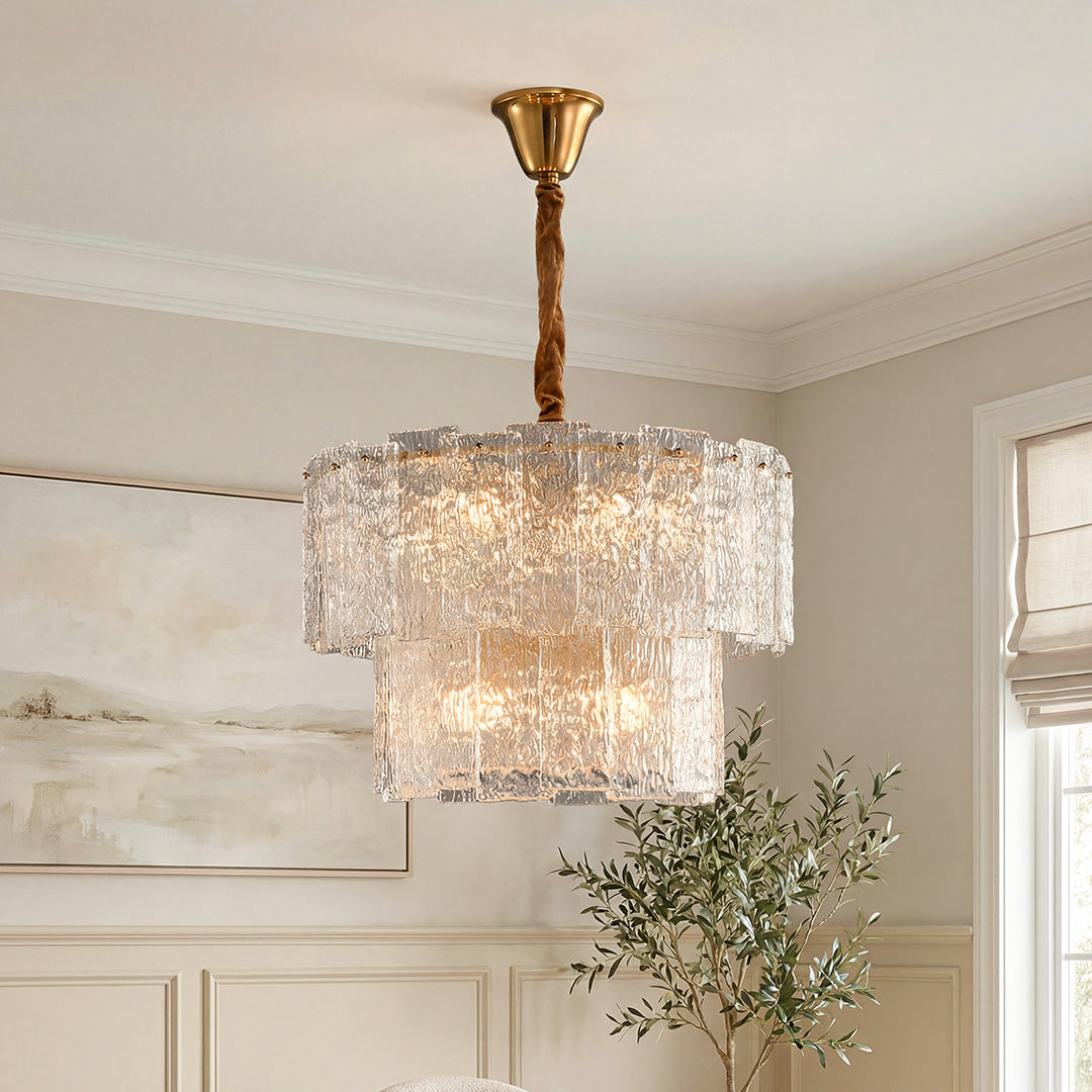 Elegant two-tiered small modern chandeliers featuring textured ice glass panels and a gold canopy in a bright living space.
