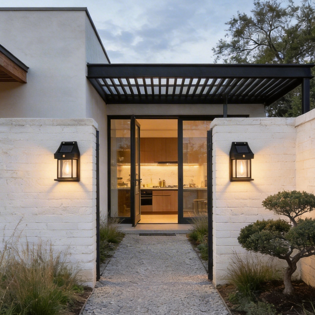 Two wall mount solar lanterns flanking a modern stone garden entrance path at twilight time ok.
