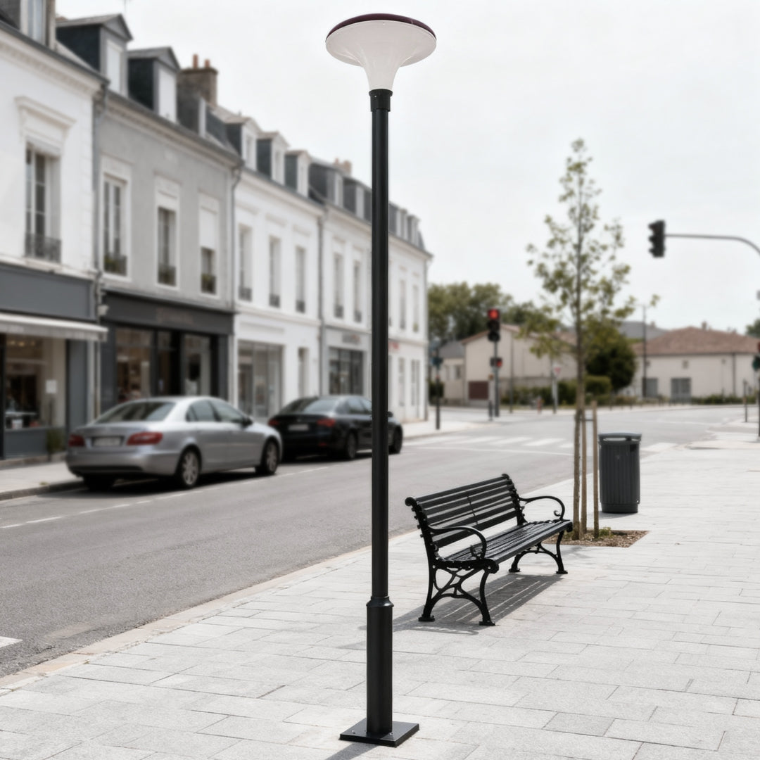 Modern UFO solar street light beside an urban sidewalk with benches and parked cars.