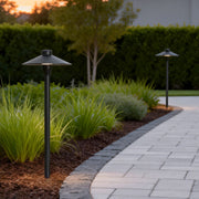 Umbrella path lamp illuminating a modern garden walkway with warm directional glow.