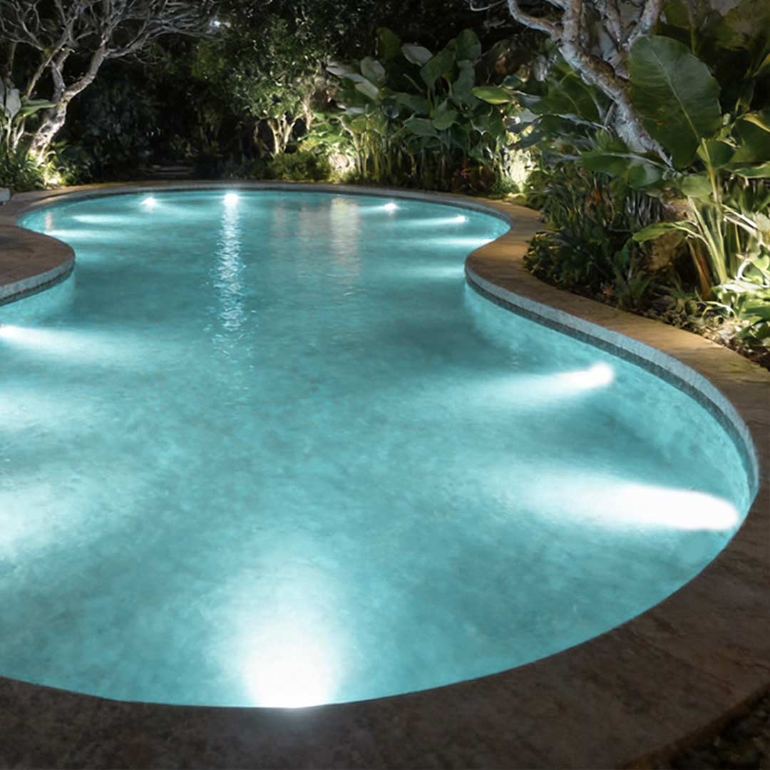 Underwater spot lights illuminating a modern swimming pool with vibrant blue glow.