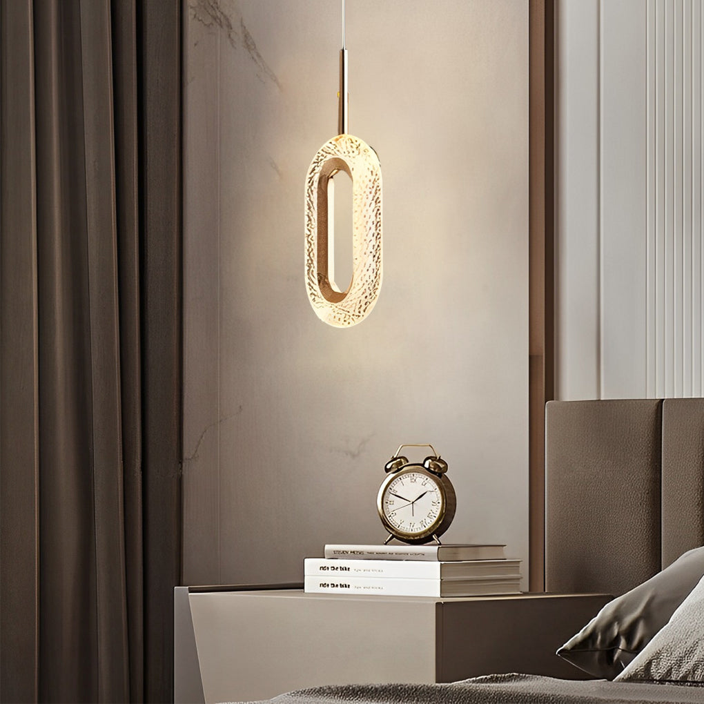 Single unique pendant light with crystal detail hanging beside a bed.