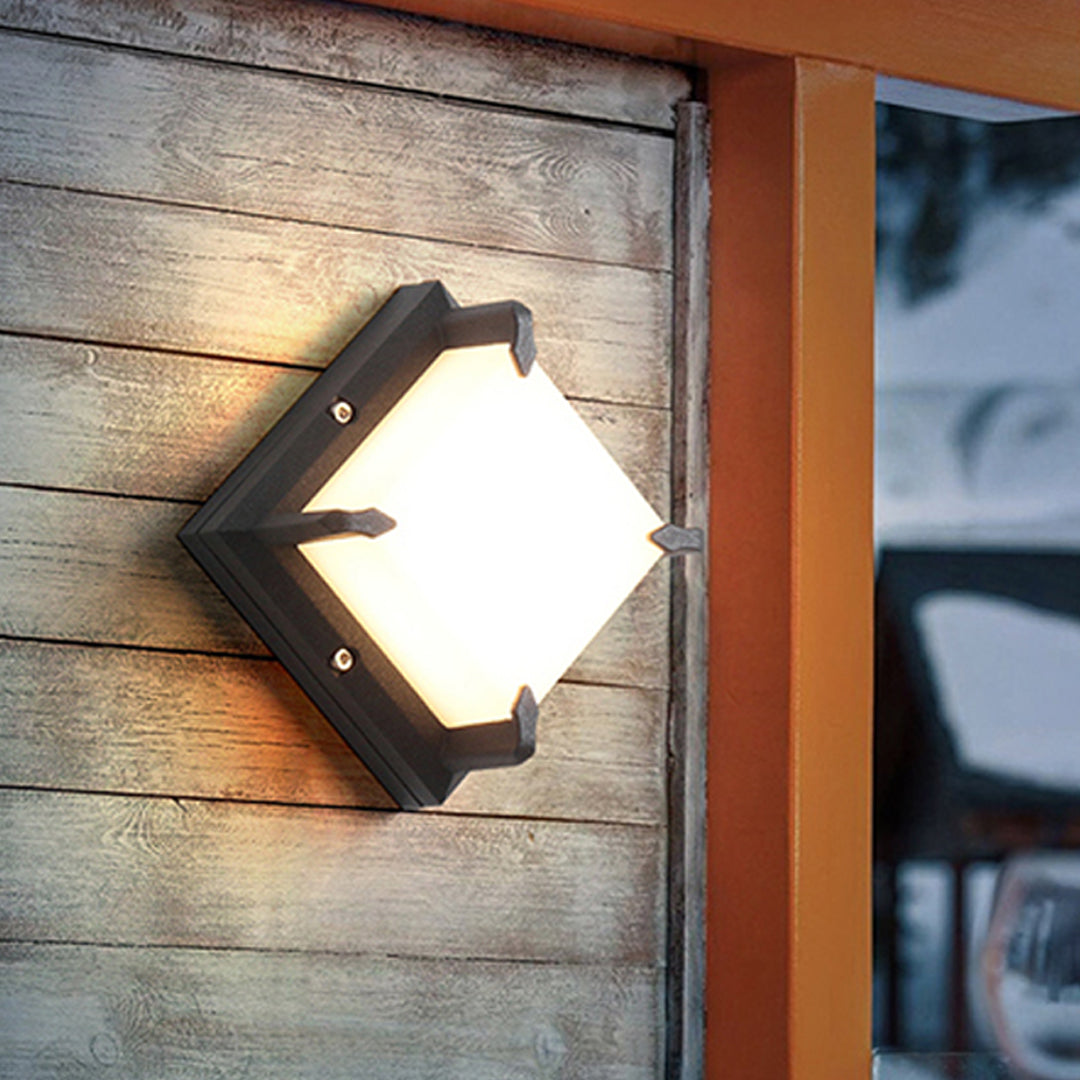 Close-up of a unique decorative Black Outdoor Wall Light with a diamond-shaped frosted lens on wooden siding.