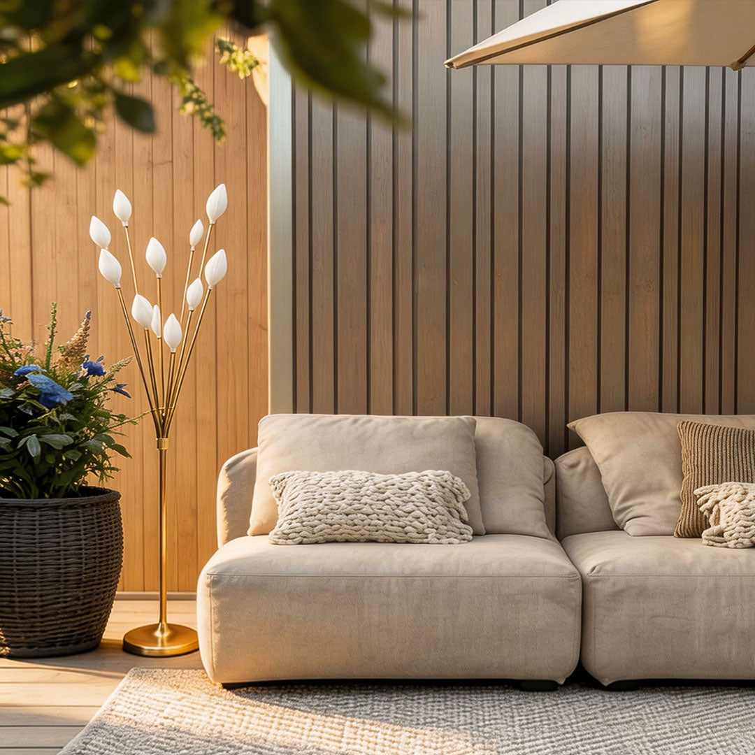 Unique decorator floor lamps on a modern wood patio next to a lounge sofa and the woven carpet rug.