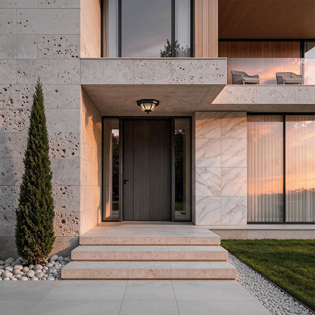 Unique flush mount lighting mounted above the entrance of a modern stone and marble home exterior.