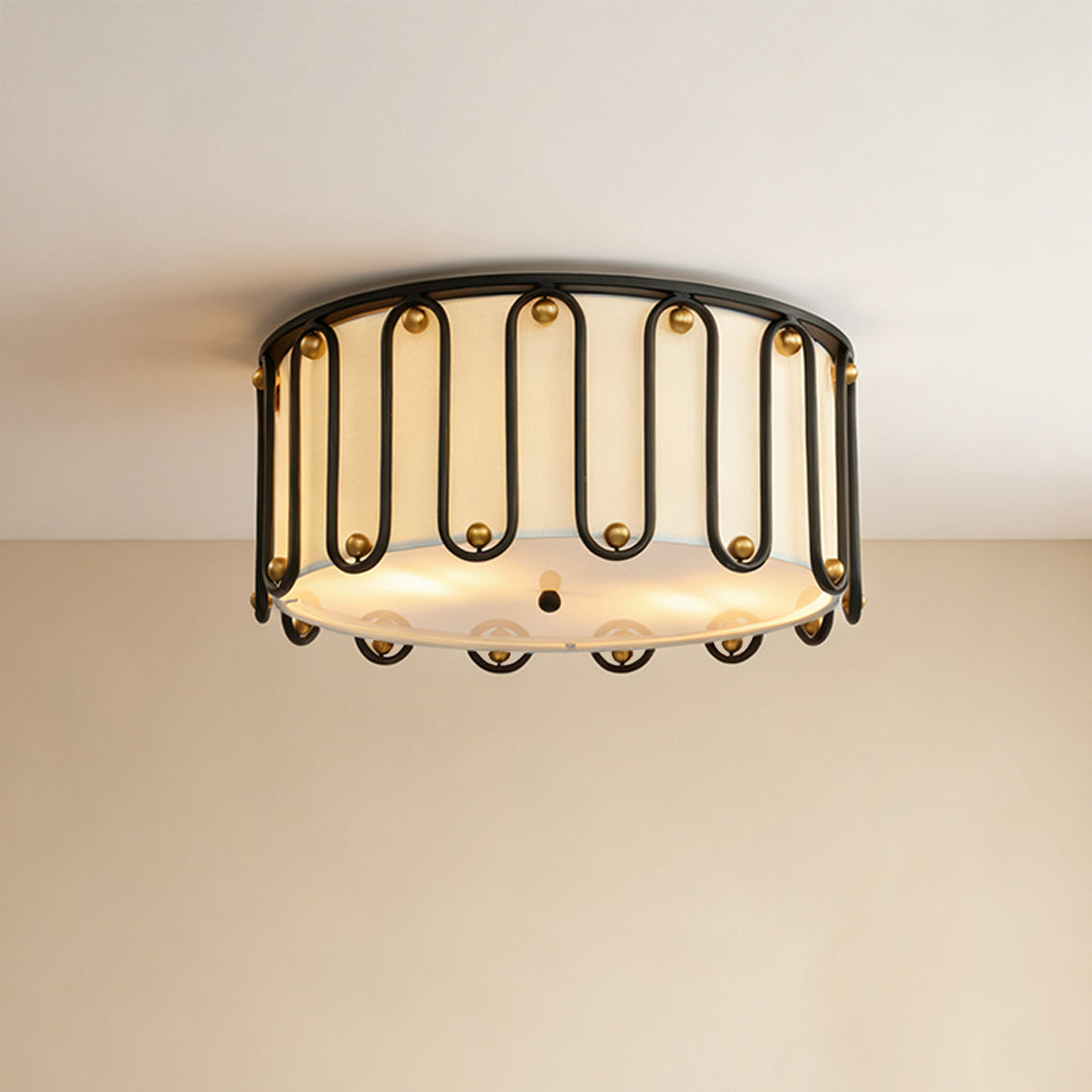 Close-up view of the unique drum ceiling light flush mount, showcasing its matte black metal frame and decorative gold accents.
