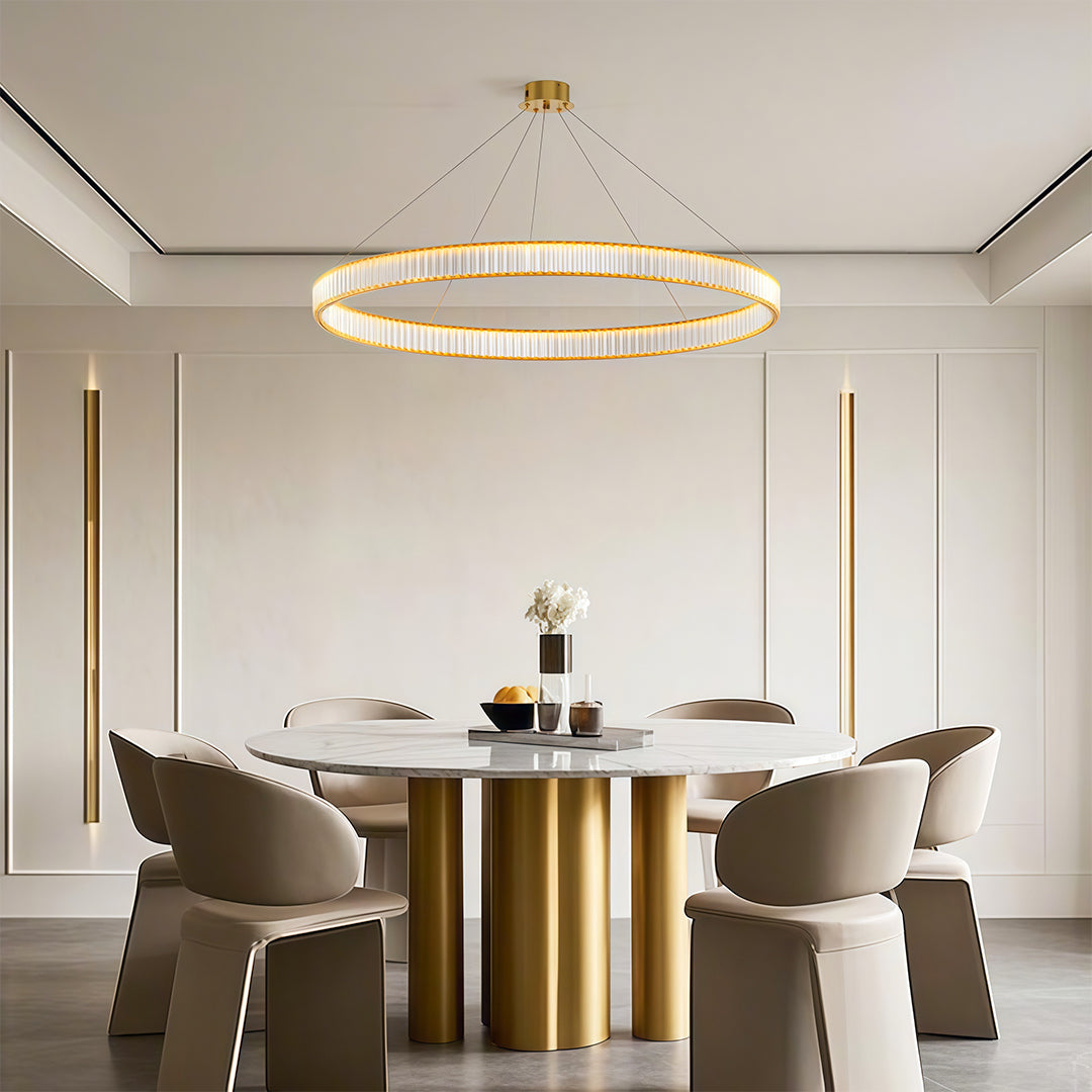 Modern luxury chandeliers creating focal point in bright dining room with brass table