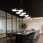 Unique modern chandelier illuminating a contemporary office meeting room with sleek, ambient glow.