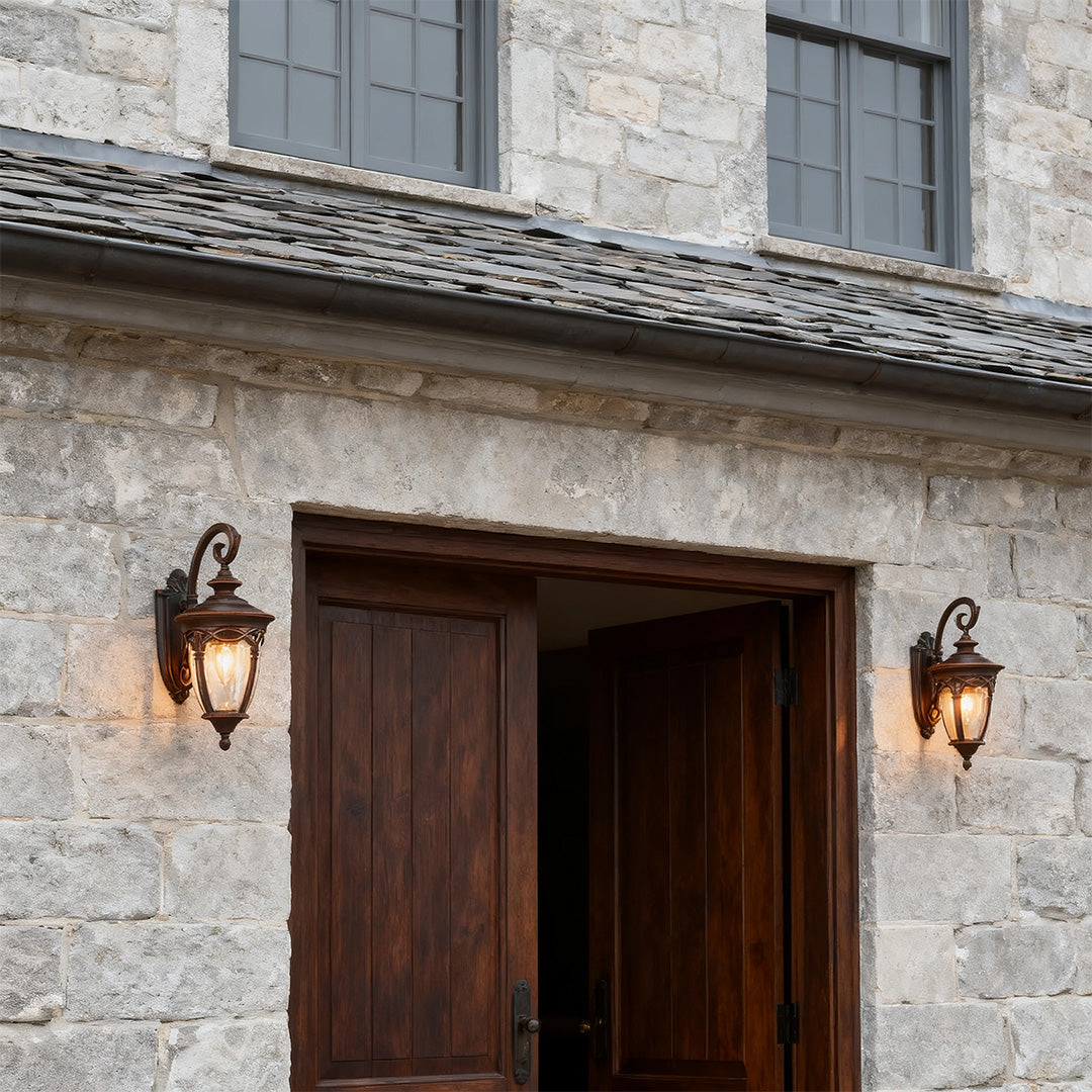Pair of unique outdoor sconces flanking rustic wooden door on stone facade entrance