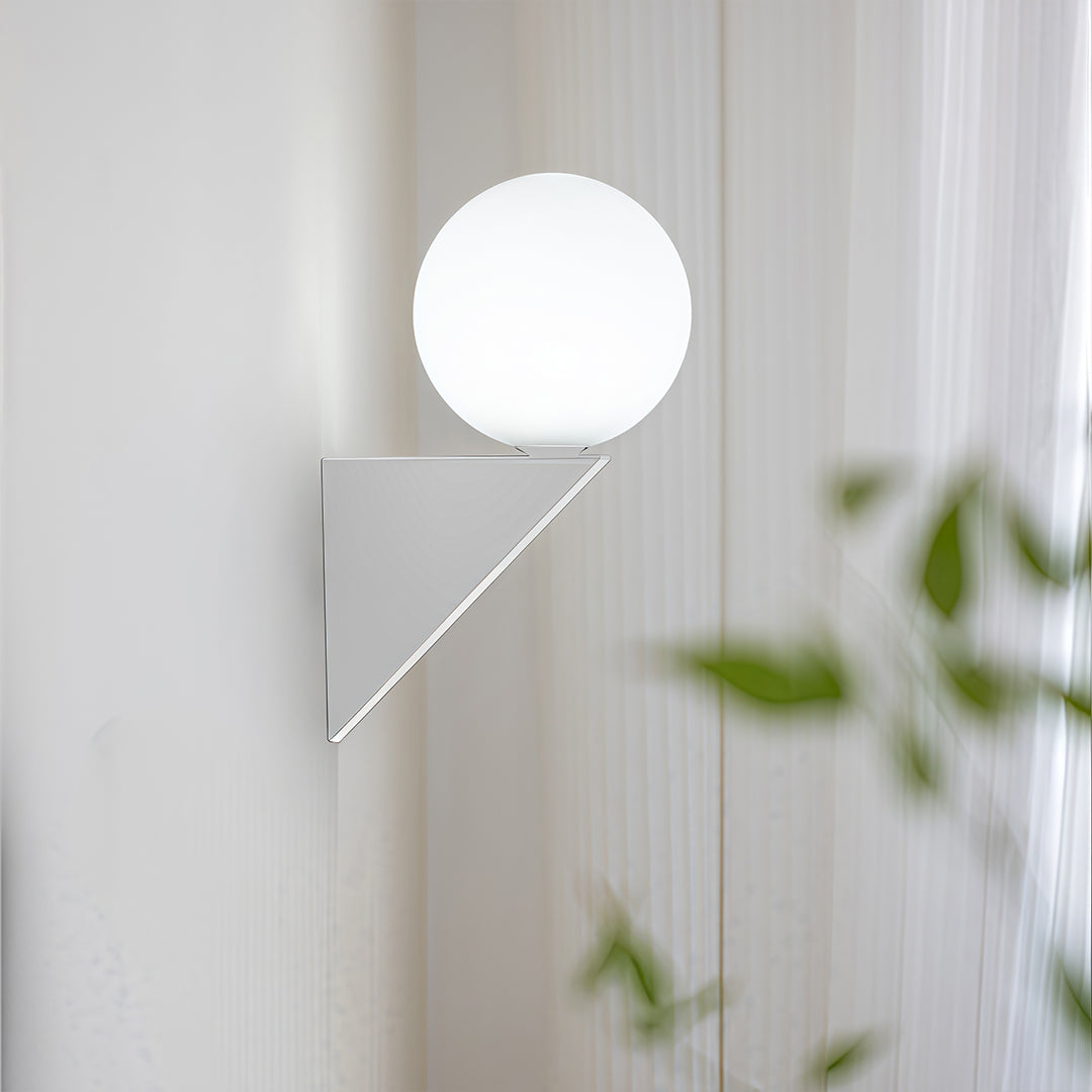 Unique white globe wall light set on a triangular mounting plate, serving as a modern sculptural lighting piece.