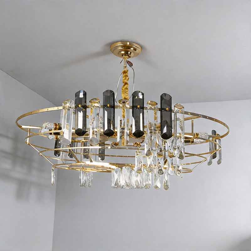 Unlit round drum crystal chandelier​ hanging from a white ceiling with grey walls in background