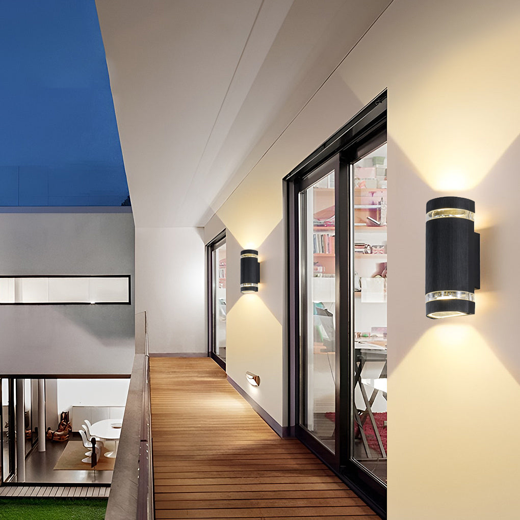 Up and down light wall sconce installed in a hallway, casting light upward and downward.