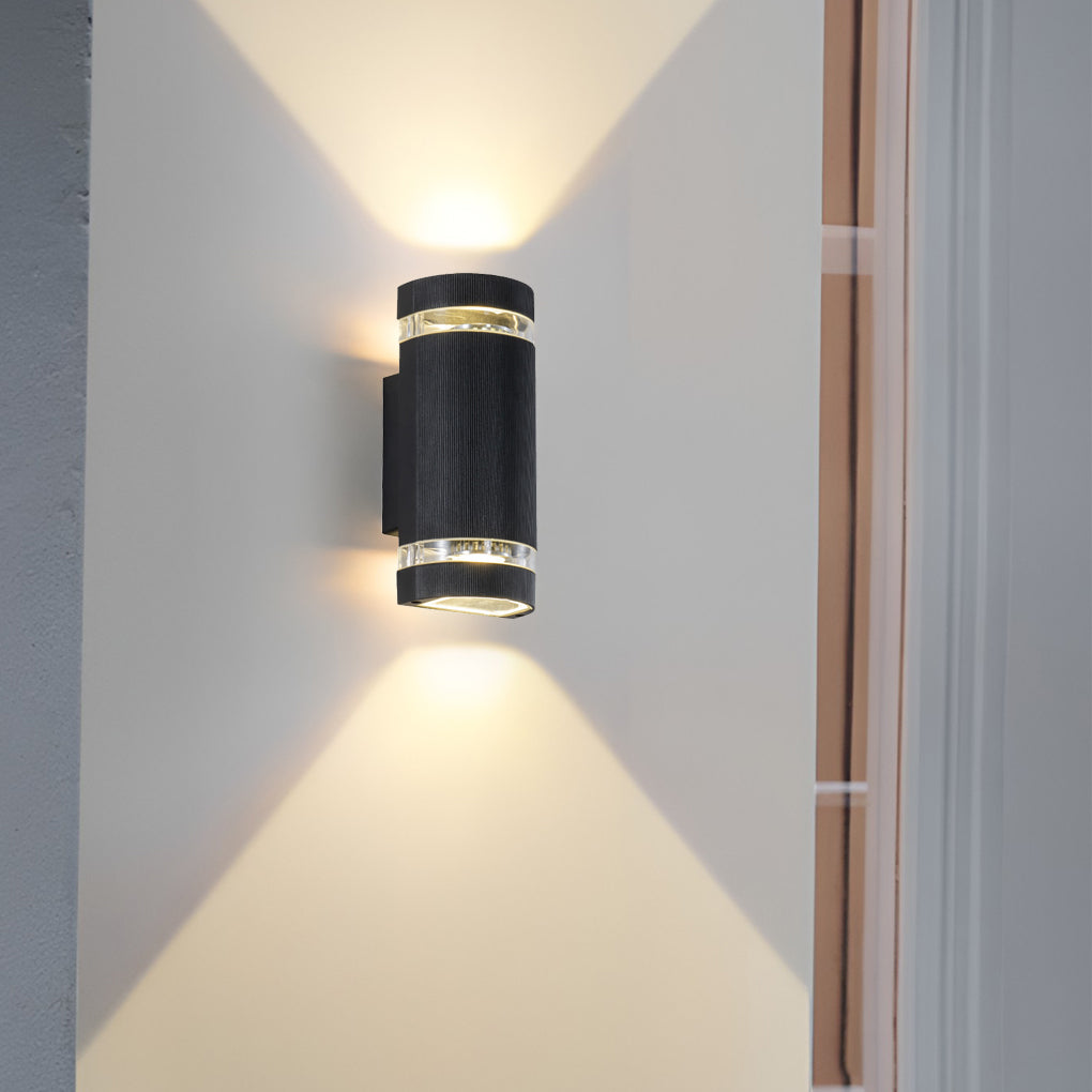 Up and down light wall sconce mounted indoors, casting focused light beams on the wall.