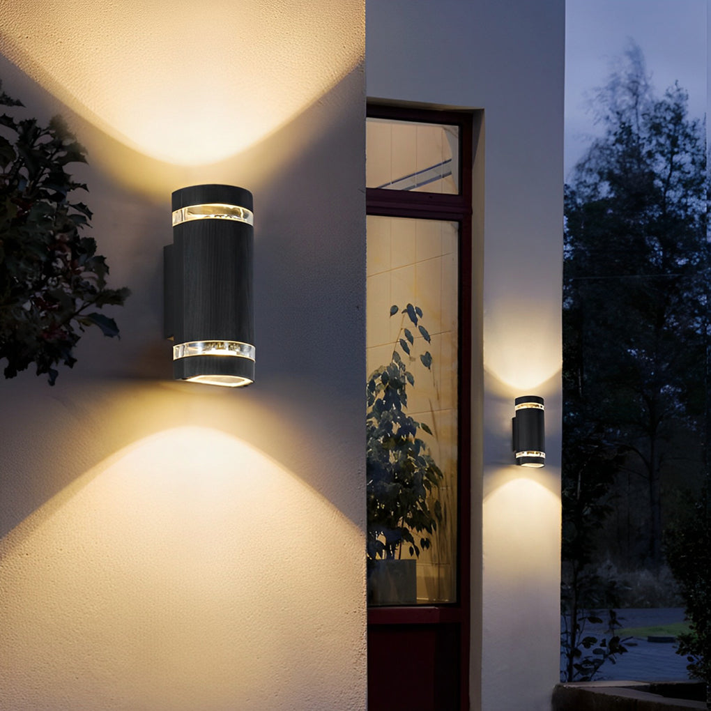 Up and down light wall sconce beside a modern entrance, highlighting architectural details.