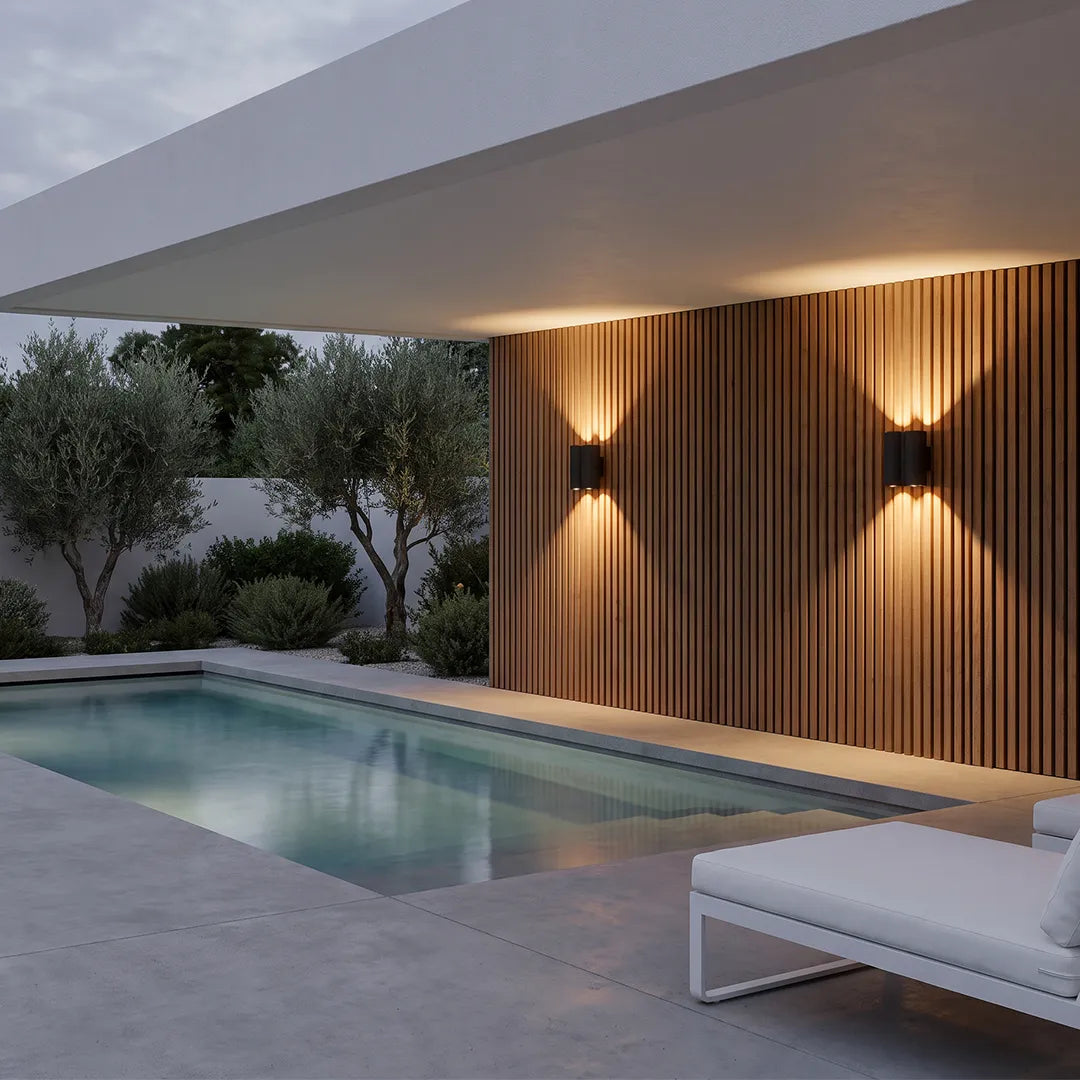 Up and down outdoor wall lights illuminating a poolside exterior wall with dramatic warm beam effects.