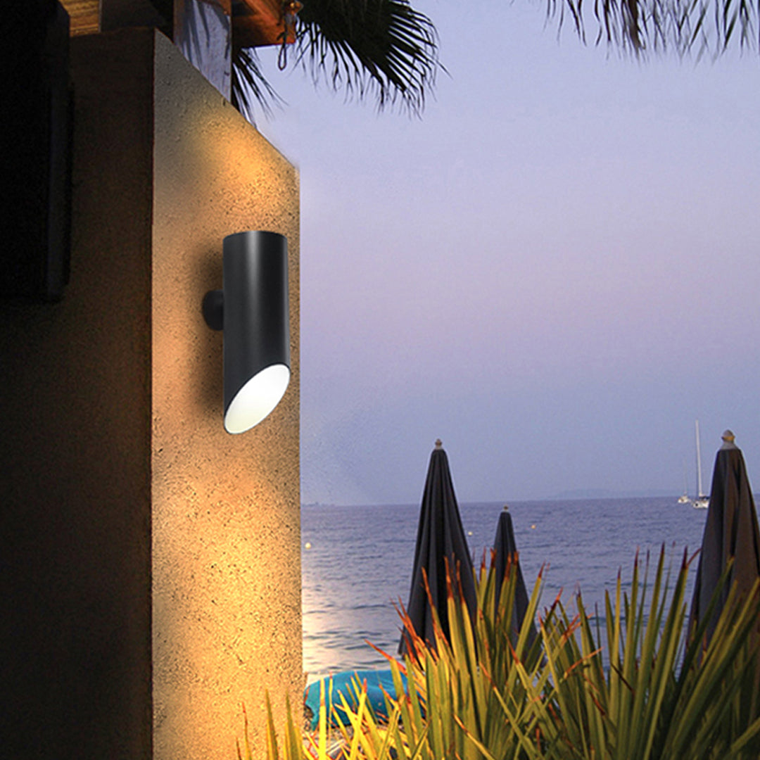 Outdoor pathway illuminated by stylish black up and down wall lights creating soft ambient glow.