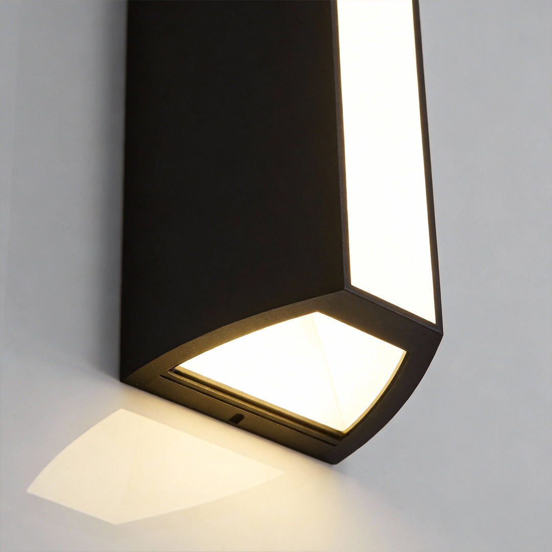 Close-up view of the lower diffuser on an up down cylinder sconce, projecting a focused downward beam of warm light.