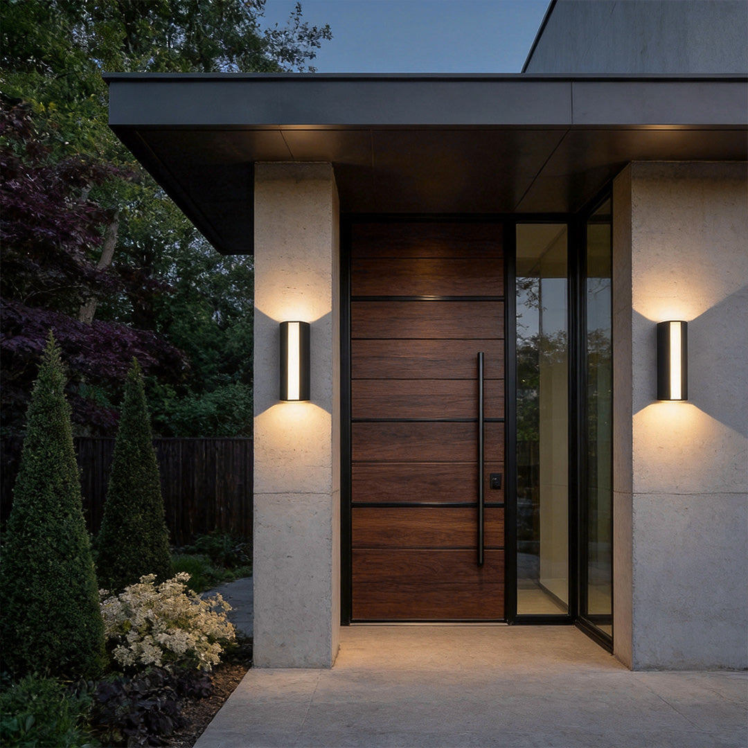 Up down cylinder sconce installed beside a front entrance door, delivering balanced architectural lighting for a contemporary facade.