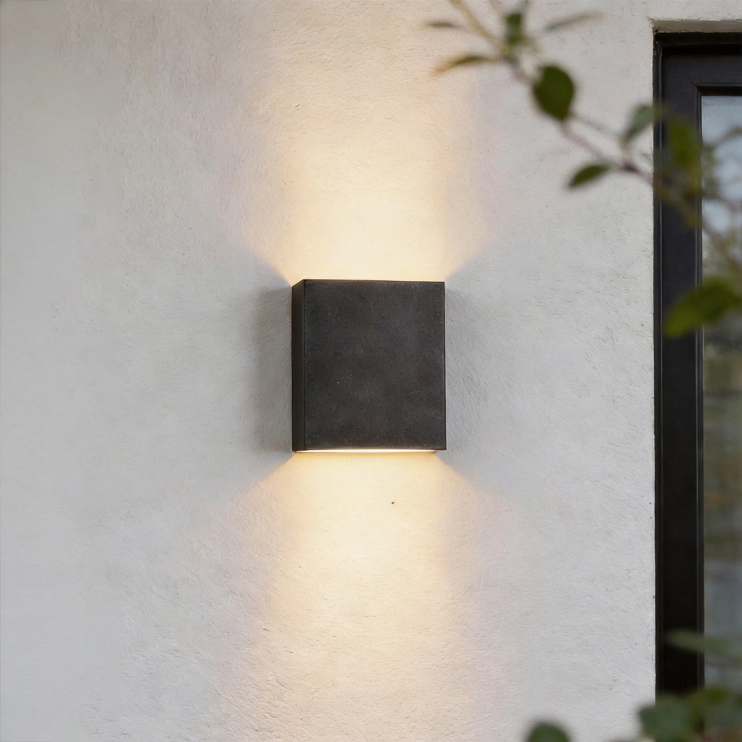 Up down lighting wall lights mounted on an exterior wall casting warm illumination above and below.