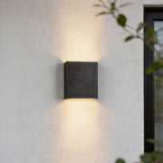 Up down lighting wall lights mounted on an exterior wall casting warm illumination above and below.