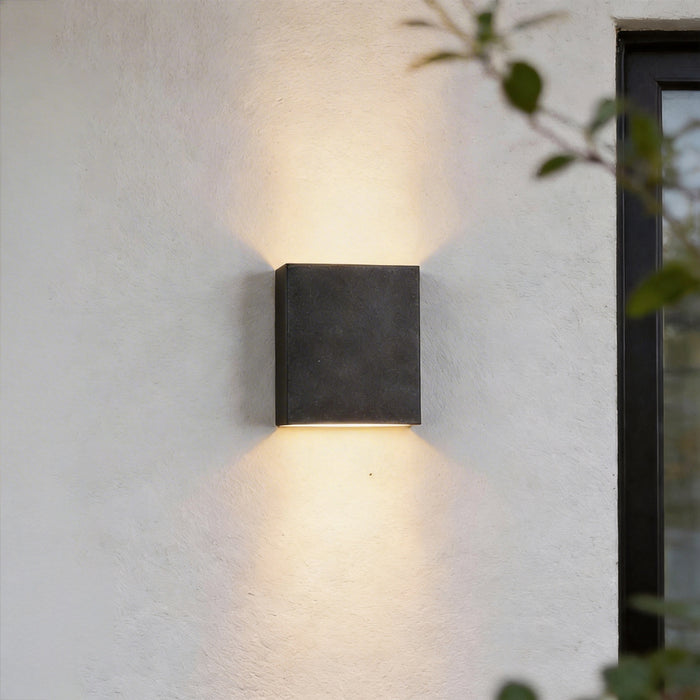 Up down lighting wall lights mounted on an exterior wall casting warm illumination above and below.