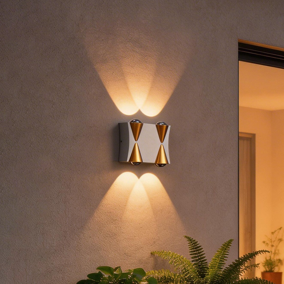 Up down lighting wall lights with a modern gold and black design, mounted beside a glass door.