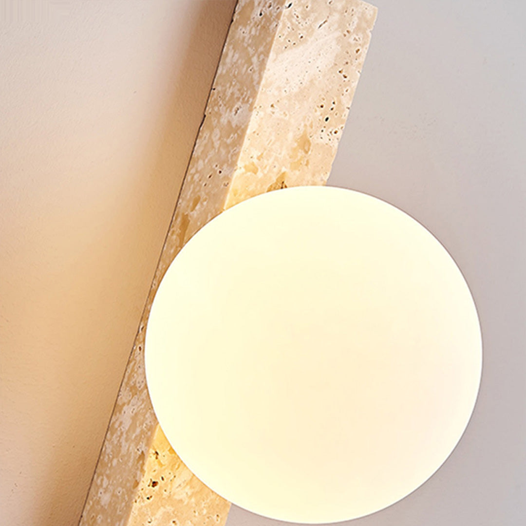 Close-up of up down lighting wall sconce showing the frosted globe and textured stone body.