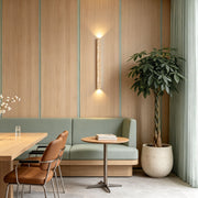 Up down lighting wall sconce installed beside a sofa with warm upward and downward illumination.